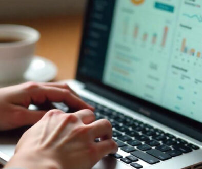 A person typing on a laptop with an analytics dashboard on the screen, exploring ways to earn online. A cup of coffee sits on the wooden table beside them.